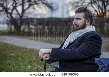 Middle Adult Bearded Man Have Rest With Closed Eyed And Smiling Face On Bench In Autumn Park