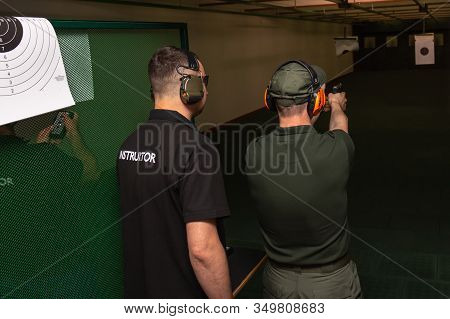 Arlamow, Poland - May, 2019: Shooting In The Dash Of Short-barreled Weapons. A Man Aims At A Target 
