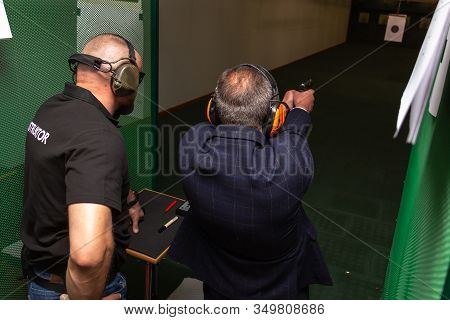 Shooting In The Dash Of Short-barreled Weapons. A Man Aims At A Target Before Firing A Pistol. The I