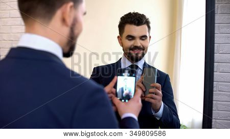 Cheerful Smiling Male In Formalwear Taking Selfie In Mirror Reflection At Home
