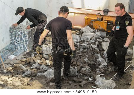 Krakovets, Ukraine - May, 2019: The Border Guard In Special Uniforms Throws Smuggled Cigarettes, Whi