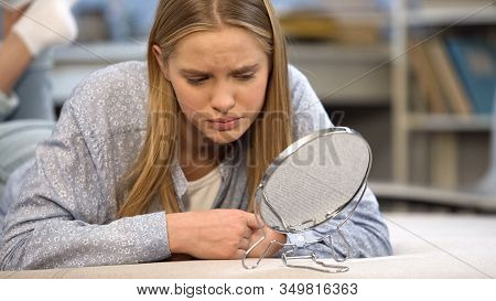 Sad Teenage Girl Underestimating Her Appearance As Looking At Mirror, Bullying