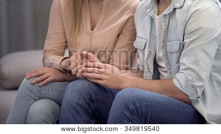 Couple Holding Hands, Sitting In Waiting Hall Hospital, Fertility Consultation