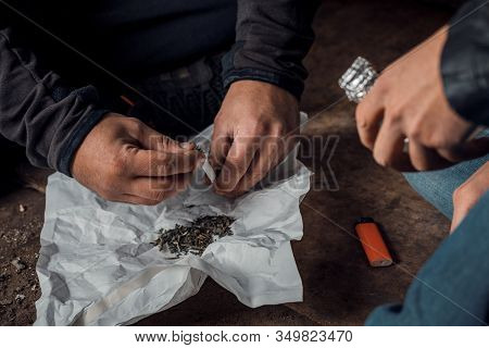 Two Shabby Men Preparing Drug Injection In Slums.