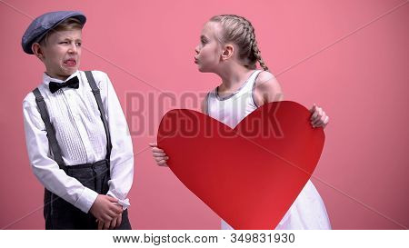 Little Girl With Red Paper Heart Trying To Kiss Young Boy Male Kid Recoils, Date