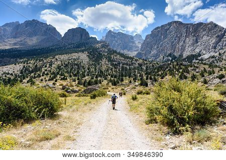 Turkey, Chamard - August 3, 2019: Tourists Walk Along The Road Through The Mountain Landscape In The