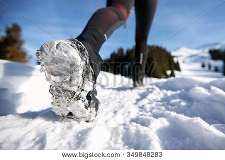 Close-up Shoes Of Trail Runner Woman Running In Winter Mountains Trail On Snow.