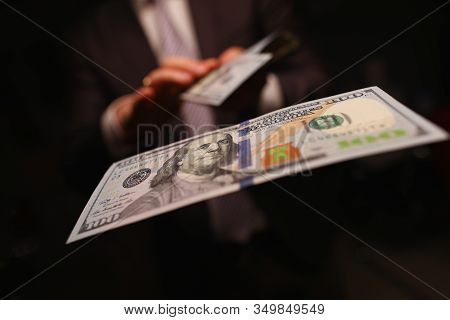 Man In Business Suit Litter Money, Dollars Closeup. Person Spends Thoughtlessly Money On Gambling An