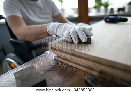 Man Sits In A Wheelchair And Works As Carpenter. Small Business For Disabled People Training Study C