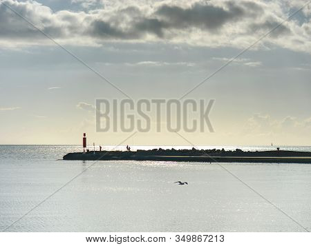 Stony Pier Or Mole With Fishermen, Small Lighthouse At The Ond Of  Promenade.