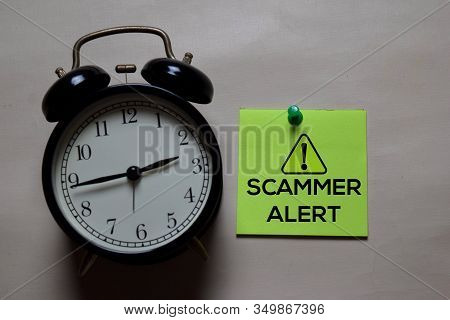 Scammer Alert Write On A Sticky Note Isolated On Office Desk
