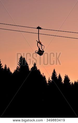 Ski Chair Lift In The Mountains At Beautiful Sunset. Vertical Photo.