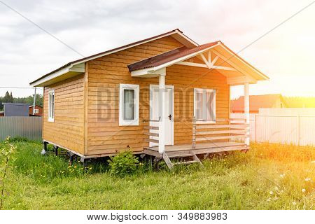 Small Tiny Wooden Frame House With Sundeck And White Windows And Door As A Country Residence In Sunn
