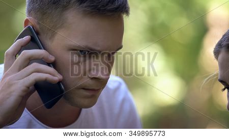 Worried Young Man Calling 911 To Report Crime Or Ask For Medical Help, Closeup