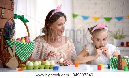 Sweet Tooth Girl Eating Forbidden Chocolate, Astonished Mum Looking At Daughter