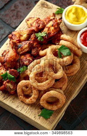 Sticky Glazed Chicken Wings And Deep Fried Battered Onion Rings Served With Lemon Wedges, Tomato Ket