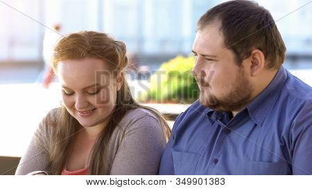 Shy Fat Couple Sitting In Outdoor Cafe During Romantic Date, Awkward Situation