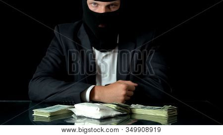 Mafiosi In Balaclava Looking At Cocaine And Money On Table, Drug Trafficking