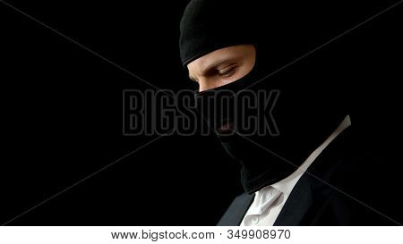 Male In Balaclava Feeling Guilty About Crime, Isolated On Black Background