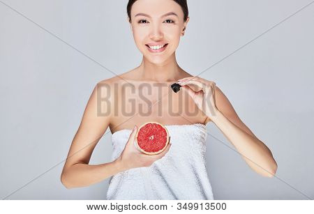 Clseup Head Shot Of Woman Holding Orange Fruit. Beautiful Young Asian Woman With Perfect Skin Is App