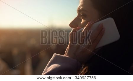 Pretty Young Woman Chatting On Smartphone On Skydeck, Reasonable Roaming Tariffs