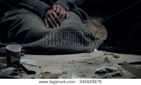 Vagabond Covered With Dirty Blanket Sitting On Carton, Living On Street, Refugee
