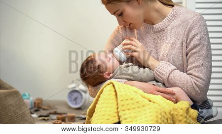 Young Lady Feeding Baby Boy, Bottle With Infant Formula, Putting Kid To Sleep