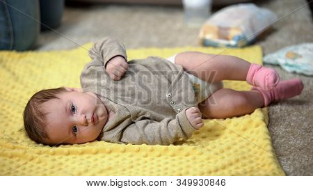 Little Baby Girl Lying Alone On Draw-sheet While Mother Is Busy, Lack Of Time