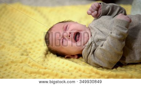 Newborn Baby Lying And Crying Suffering Abdominal Colic, Emergence Of Tooth