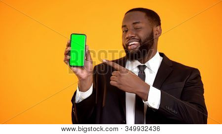 Afro-american Male In Suit Pointing At Prekeyed Phone And Winking, Advertisement