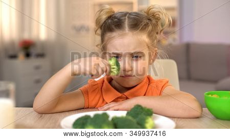 Upset Girl Looking At Broccoli With Disgust, Full Of Vitamins But Tasteless Food