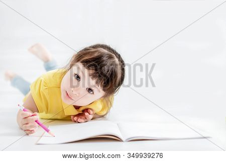 Cute Beautiful  Little Girl Drawing  On The Flloor