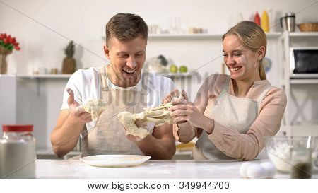 Carefree Couple Clumsily Kneading Dough, Having Fun In Kitchen, Inept Chefs