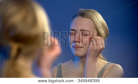 Crying Teen Female Disinfecting Face Wound Looking In Mirror Reflection, Despair