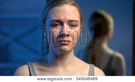 Young Crying Female Teenager Crying And Looking To Camera, Suffering Depression