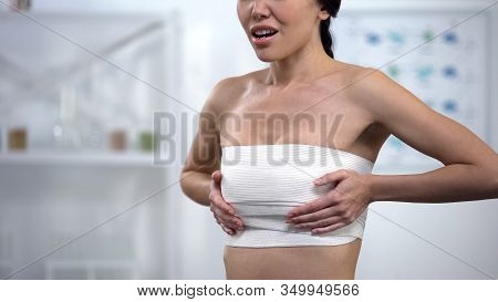 Woman In Elasto-fit Breast Compression Touching Wrap, Feeling Pain After Surgery