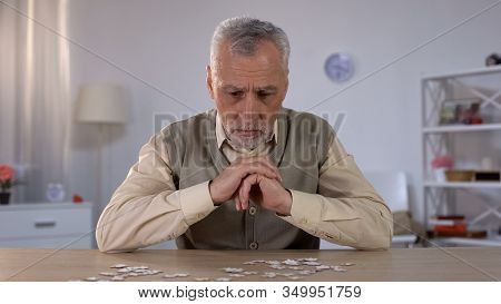 Old Man Exercises With Puzzle, Suffers Cognitive Impairment, Alzheimer Symptom