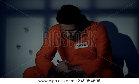 Male Caucasian Prisoner Sitting In Cell, Feeling Guilty About Crimes, Conviction