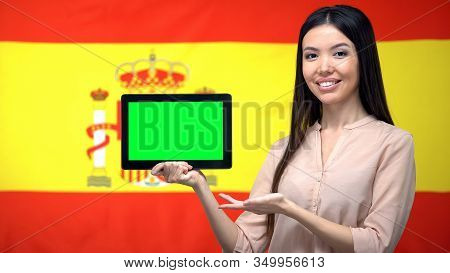 Girl Holding Tablet With Green Screen, Spanish Flag On Background, Migration