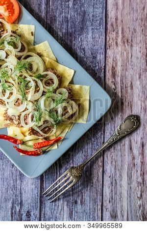 Beshbarmak Is A National Kazakh Dish - Square Pasta With Boiled Meat And Onions. On Wooden Backgroun
