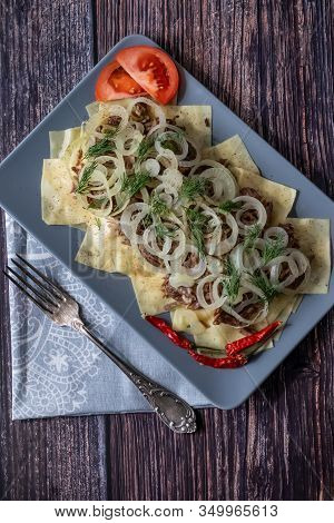 Beshbarmak Is A National Tatar Dish - Square Pasta With Boiled Meat And Onions. On A Black Backgroun