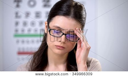 Unhappy Woman In Eyeglasses Holding Head, Feeling Migraine Pain, Symptom