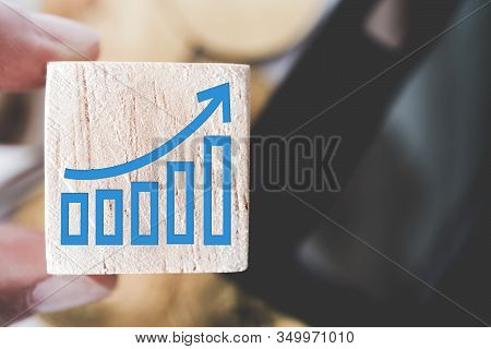 Graph Rising Up Growht Exponencial Sign On Wooden Cube With Objects Such As Gold Coin, Calculator An