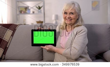 Smiling Mature Lady Holding Green Screen Tablet In Hands, Easy Banking, Shopping
