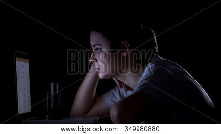 Girl Freelancer Working On Laptop Late At Night, Looking Tired And Sleepy