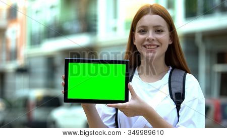 Smiling Girl With Backpack Showing Green Screen Tablet, Cheap Tours And Flights