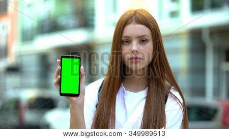 Red-haired Girl Showing Smartphone With Green Screen, Free Navigation App