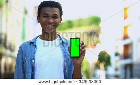 Smiling Teenager Holding Smartphone With Green Screen, Navigation Application