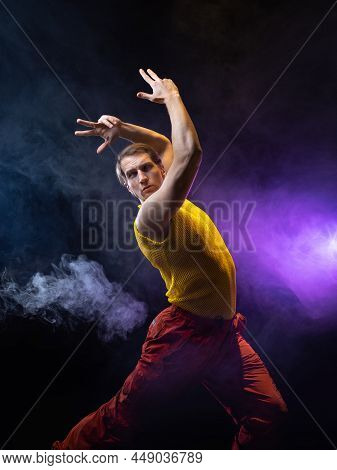 A Young Muscular Man In A Bright Outfit Poses In A Pretentious Pose, Style And Grotesque. Attractive