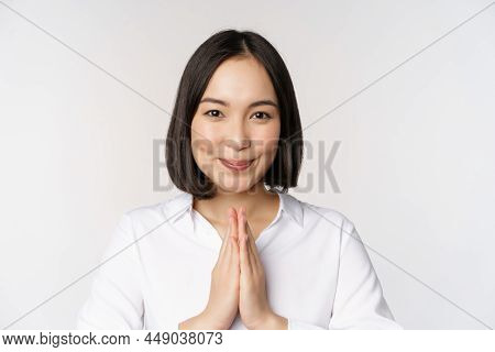 Close Up Portrait Of Young Japanese Woman Showing Namaste, Thank You Arigatou Gesture, Standing Over